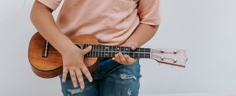 kid holding ukulele