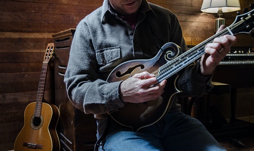 a man playing on his mandolin - how hard is it to learn Mandolin