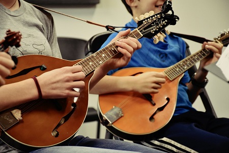 guys playing mandolin in group
